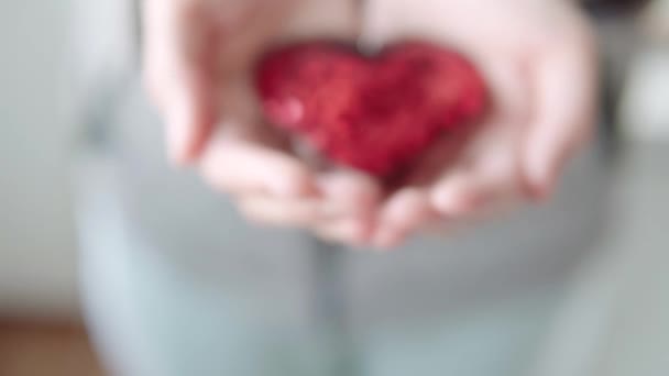 Vedere Aproape Unei Inimi Roșii Strălucitoare Decorative Strălucitoare Mâinile Unei — Videoclip de stoc