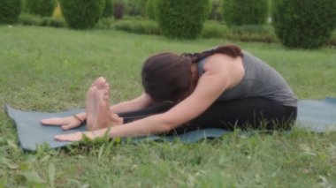 Professional yoga instructor. Seated Forward Fold, Paschimottanasana, Seated yoga pose, flexibility, mobility concept.