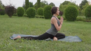 Yoga instructor practicing pigeon pose, namaste gesture, namaste mudra. 4k footage.