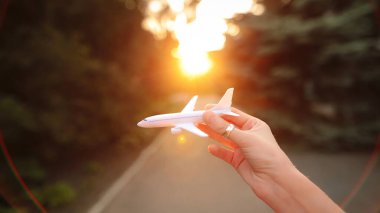 El ile uçak uçuş akşam taklit eder. Güneş ışınları objektif vurdu. Gezi rüyalar.