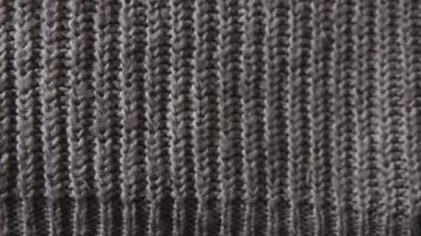 Gri akrilik kumaş örülmüş. Detaylı görüntü. Süveter, sıcak ekose, atkı. Örgü tekstil geçmişi var. Yüksek kalite 4k görüntü.