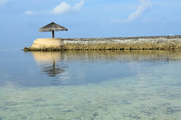 Indian ocean with marine pies and beach umbrella Maledives — Stock Photo, Image