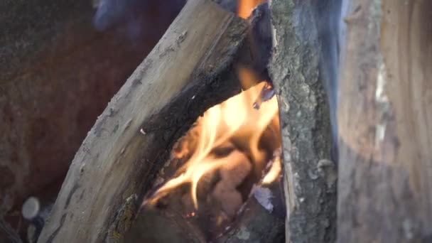 Egy közeli felvétel a tűzifa felaprításáról. Tűz a fán, fát éget egy kandallóban. A tűz máglyája. Égő narancssárga láng a fán. Nagyon forró faszén égő egy grill 4k — Stock videók