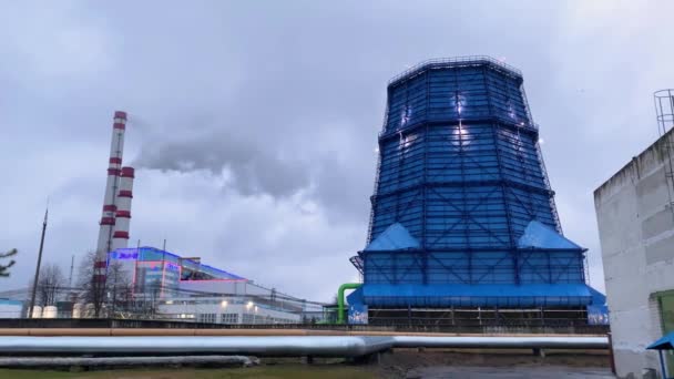 Pipes of the thermal power station of the CHPP and cooling tower. Puffs of white smoke and fumes. Air pollution. Carbon dioxide emissions, Energy of smoke and steam 11.06.2021 Minsk Belarus — стоковое видео