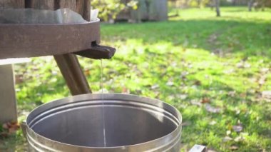 Evde eski bir metal akvaryum metodu kullanarak meyve suyu hasat etmek. Güzel bir kırsal sonbahar manzarası. Çürümüş ahşap bir ahır. Günbatımında sonbahar renkleri olan güzel bir bahçenin yanında.