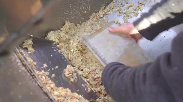 Мужские руки сгребают дробленую яблочную пасту для производства сидра, размазанную машиной из резервуара из нержавеющей стали. Фруктовая витаминная паста. Сырая вегетарианская концепция здорового питания 4k — стоковое видео