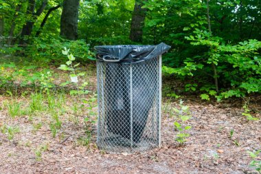 Parktaki metal kafes çöp tenekesi.