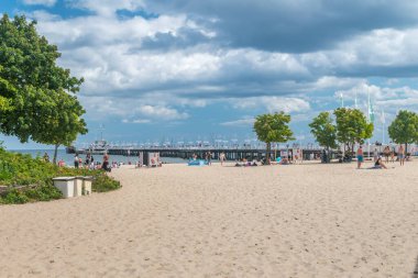 Sopot, Polonya - 1 Ağustos 2021: Arka planda ahşap iskelesi olan Sopot şehir plajı.