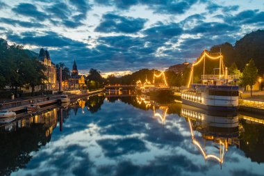 Turku, Finlandiya - 5 Ağustos 2021: Aydınlatılmış gemilerle Aurajoki nehrinin güzel gün batımı manzarası.