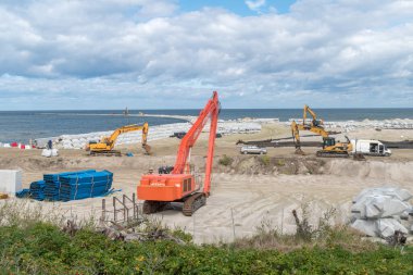 Skowronki, Polonya - 17 Ağustos 2021: Vistula Spit kanalı inşaatı sırasında kazıcılarla birlikte Baltık Denizi plajına bakın.