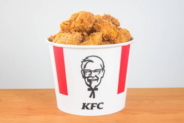 Pruszcz Gdanski, Polonya - 23 Ağustos 2021: Bir sürü KFC tavuk kanadı KFC (Kentucky Fried Chicken) fast food. Harland Sanders simgesiyle ikonik kova.