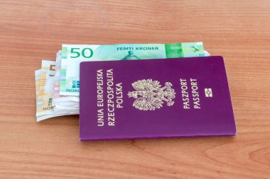 Norveç kronu (NOK) ile Polonya biyometrik pasaportu ahşap masa üzerinde.