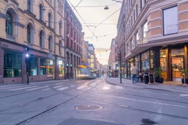 Oslo, Norway - September 24, 2021: Street view with tram track in city centre with beautiful sunrise in Oslo.