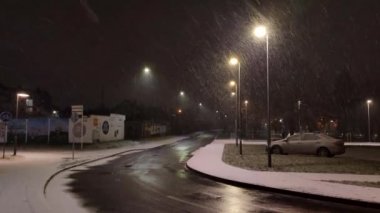 Pruszcz Gdanski, Polonya - 1 Şubat 2022: Kar fırtınasında yan cadde. Geceleri sokak ışıklarına kar yağar.