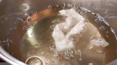 Metal tencerede kızartma meleği kanadı. Şişman Perşembe için melek kanatları hazırlanıyor. Şişman Perşembe geleneksel Hıristiyan ziyafetidir.