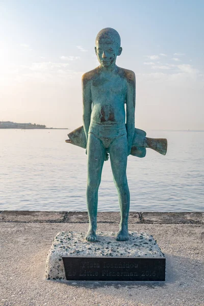 Paphos, Kıbrıs - 2 Nisan 2022: Yiota Ioannidou 'nun küçük balıkçısı. Balıklı bir çocuğun bronz heykeli..