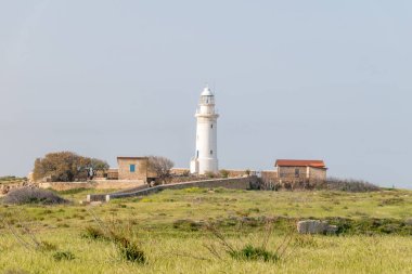 Akdeniz kıyısındaki Paphos deniz feneri. Paphos şehrindeki arkeoloji parkında beyaz deniz feneri..