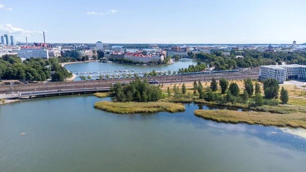 Helsinki, Finlandiya - 5 Ağustos 2021: Helsinki şehir merkezindeki Toolonlahti körfezinde Merkez Tren İstasyonu yakınlarında demiryolu ile havadan görüş.