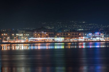 Paphos, Kıbrıs - 2 Nisan 2022: Paphos şehri gece görüşü. Paphos şehrini denizden izle.