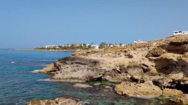 Paphos 'taki Akdeniz kıyısında kayalık bir sahil şeridi. Kıbrıs 'ın kayalık sahillerinde küçük dalgalar.