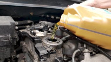 Pruszcz Gdanski, Poland - May 7, 2022: Pouring Petronas car oil into car engine.