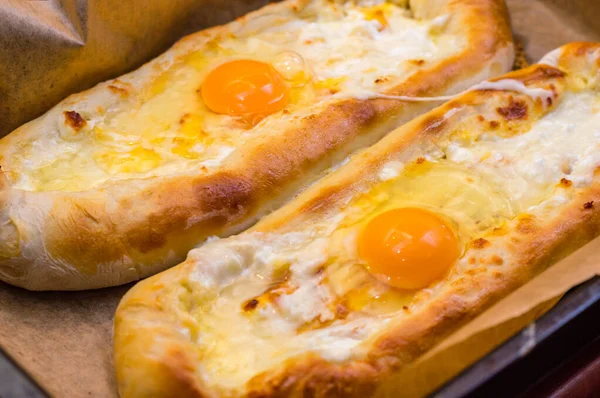 Üstünde çiğ yumurta olan Gürcü Khachapuri 'nin detayları. Khachapuri geleneksel bir Gürcü yemeğidir..
