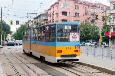 Sofia, Bulgaria - June 6, 2022: Blue and yellow tram on tram stop in Sofia.