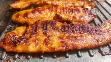 Grilling pork belly meat on electric grill. Cooking pork belly on a grill.