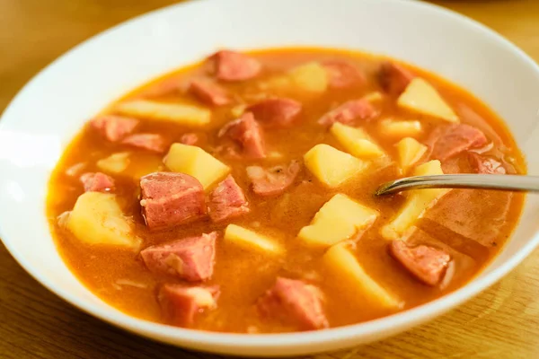 Leckere Traditionelle Tschechische Gulaschsuppe Mit Würstchen Und Kartoffeln Burtgulas Weißer lizenzfreie Stockfotos