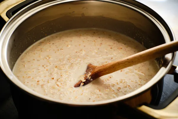 Menyiapkan Bubur Oatmeal Lezat Dalam Panci Masak Stok Gambar