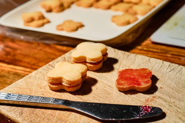 Spread Currant Jam Pada Natal Cookie Dengan Pisau Kayu Memotong — Stok Foto