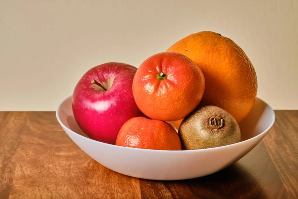 Cuenco Con Fruta Manzana Naranja Kiwi Mandarina Sobre Una Mesa Imagen de stock