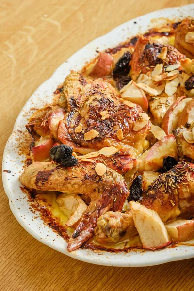 Lezzetli kızarmış tavuk, kuru üzümlü ve beyaz kasede elmalı.