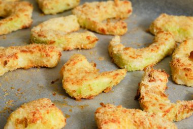 Tasty breaded pattypan squash on baking paper