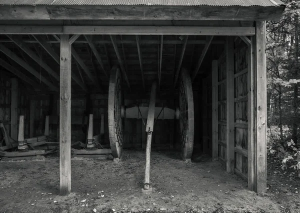黑色和白色照片中的老式马拉车或带有木制轮毂的推车和用于伐木的雪橇现在陈列在圆木滑道俯瞰处 并躲藏在一个木屋里 — 图库照片