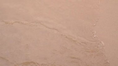 B-kaydını yakın çekimde suya bakarken dalgalar bir göldeki kumsala vuruyor kabarcıklar yaratıyor ve kıyıya sıçrıyor..