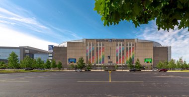 Chicago, IL - 8 Haziran 2022: Berrak bir çarşamba sabahı United Center basketbol sahasının önündeki boş bir otoparkın üzerine sarkık yeşil ağaç dalları.