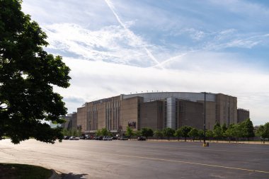 Chicago, IL - 8 Haziran 2022: Güneşli bir çarşamba sabahı United Center basketbol sahasının önündeki boş otoparkın yanında uzun yeşil bir ağaç oturuyor.