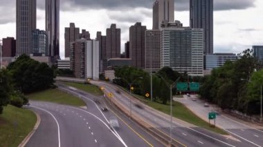 Atlanta, GA - 7 Mayıs 2022: Şehir merkezindeki Jackson Caddesi yakınlarındaki trafik akışı, güneş batıda parlamaya başladığında şehrin ufuk çizgisi üzerinde ağır bulutlar hareket ediyor..