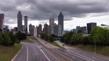 Atlanta şehir merkezinden Jackson Caddesi köprüsüne doğru hızla yaklaşın. Otoyola bakan araç trafiğinde hareket bulanıklığı ve aşağıdaki yolda ağır bulut örtüsü var..