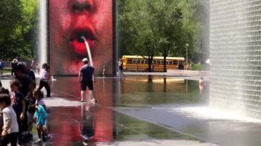 Chicago, IL - 12 Temmuz 2022: Genç bir adam sıcak bir yaz gününde Michigan Bulvarı 'ndaki halka açık bir parkta çeşmeye doğru koşuyor..