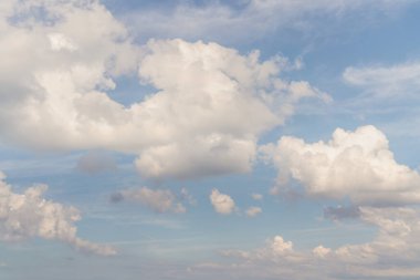 Beautiful well balanced sky replacement background with layers of fluffy white cumulus clouds on a blue sky background.