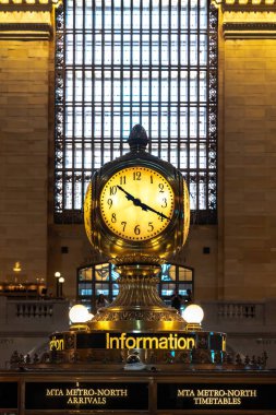A close up photo of the Grand Central Terminal clock in New York City sitting on top of the information booth inside the atrium.