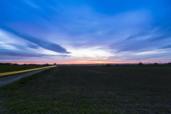 Sunset sky storm field clouds landscape long exposure motion blue hour — Stock Photo, Image