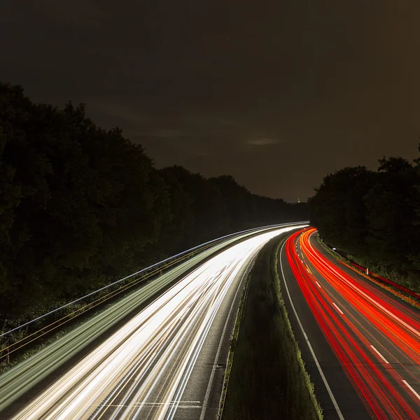 Long time exposure freeway cruising car light trails streaks of light highway electricity pylon sky — Stock Photo, Image