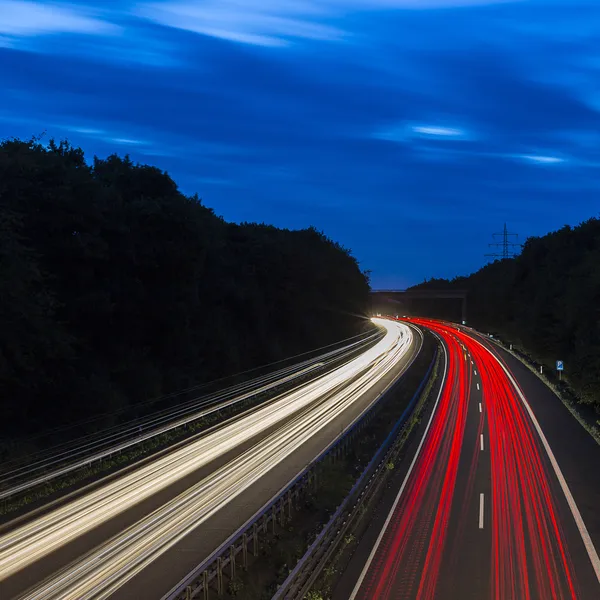 Long time exposure freeway cruising car light trails streaks of light highway electricity pylon sky — Stock Photo, Image