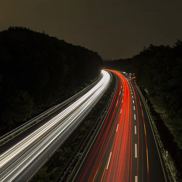 Long time exposure freeway cruising car light trails streaks of light speed highway cloudy sky — Stock Photo, Image