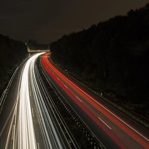 Long time exposure freeway cruising car light trails streaks of light speed highway cloudy sky — Stock Photo, Image