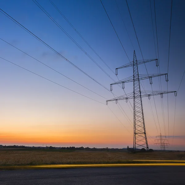 Potencia poste puesta del sol larga exposición alta tensión electricidad energía energía crepúsculo —  Fotos de Stock