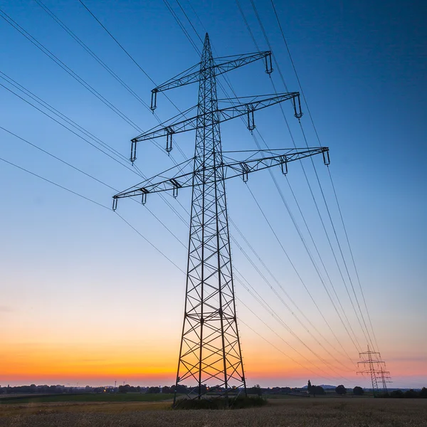 Elettricità ad alta tensione pilone tramonto blu ora energia energia elettricità crepuscolo — Foto Stock